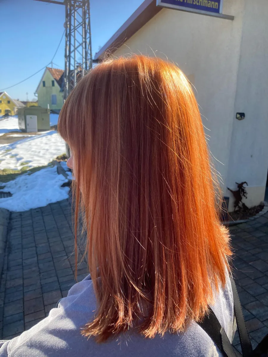 Blonde Braut mit romantischer Hochsteckfrisur und weißer Lilie im Haar